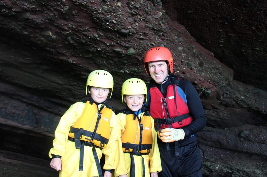 Torquay: Coasteering 5<em> Geopark Tour in Torquay – Meeting the orange van at The Thatched Tavern’ /></p>
<p><p>The meeting point is outside The Thatched Tavern pub. Look for the orange van, which makes the arrival point easier to identify.</p>
</p>
<p><p>Parking is available nearby, but parking fees are not included. You also need to arrange your own transport to and from the meeting point. That makes this easiest if you have a car or have already planned how to reach Maidencombe from Torquay.</p>
</p>
<p><p>Arrive ready to change into activity clothing. You need swimwear, a towel, a change of clothes, sunscreen, and footwear suitable for wet rocks. Old trainers or water shoes are best. These can be borrowed if needed, but bringing your own well-fitting pair is likely to be more comfortable.</p>
</p>
<p><p>Long socks are not included. The supplied gear includes old shorts, but you should still bring swimwear for underneath the wetsuit. Alcohol and drugs are not permitted, which is a sensible rule for an activity involving cold water, climbing, and jumps.</p>
</p>
<h2>Kitting up before entering the water</h2>
<p><img width="900" height="599" decoding="async" src=